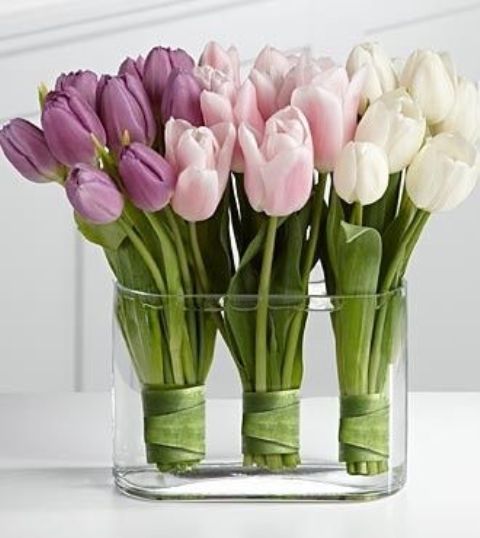 A large clear glass bowl with three tulip arrangements   in white, blush and lilac for creating an ombre effect