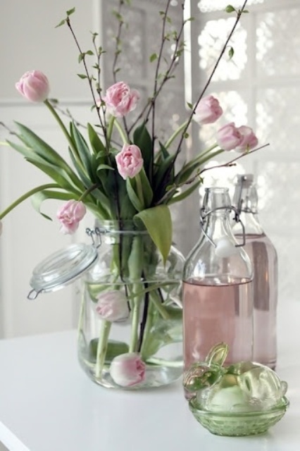 a large clear jar with pink tulips is a cool spring or Easter decoration in a soft spring-like color