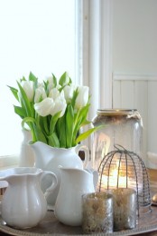 a white jug with white tulips and candles is a stylish vintage-inspried combo for spring or Easter