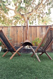a small outdoor sitting space with a brown Malm fireplace and matching stained wooden chairs – you won’t need anything else to enjoy fresh air and fire