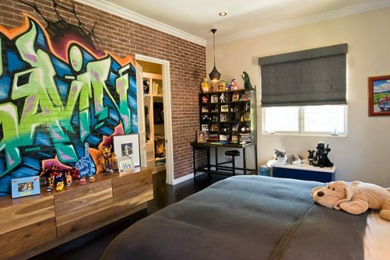 a kid's room with comfortable dark furniture and a super bold graffiti accent wall that brings color and interest to the space