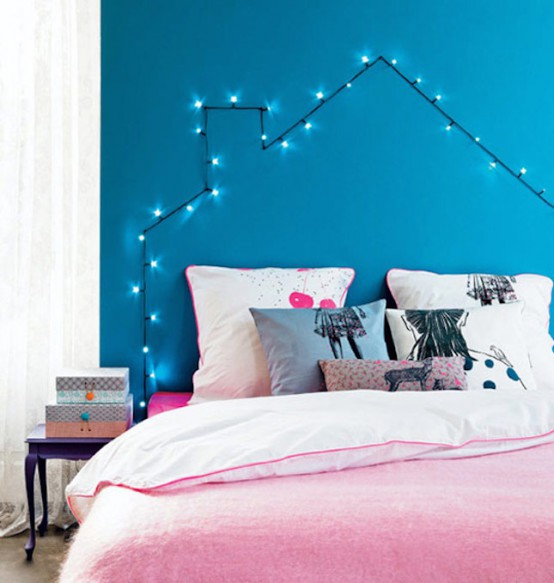 a colorful teen bedroom with a blue accent wall and string lights forming a house as a creative headboard and additional light in the room