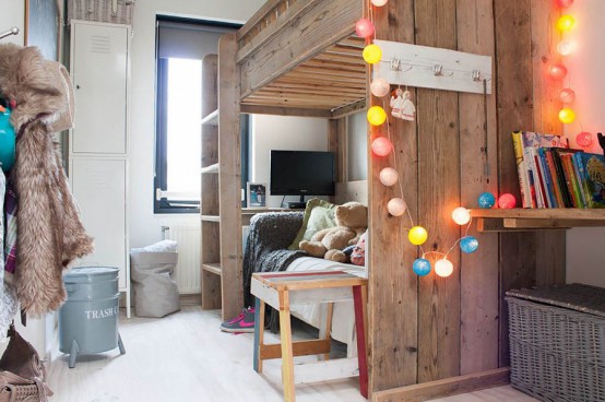 a shared farmhouse bedroom with a stained shared bed, a colorful string light garland and some pretty details that make this space very cozy