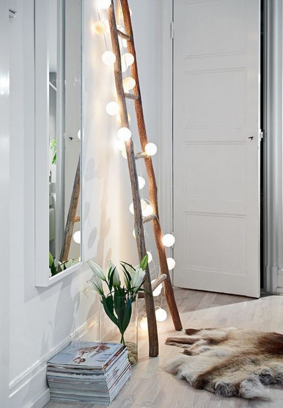 a ladder with lights attached can be a cute decoration and storage unit for any space, not only a bedroom