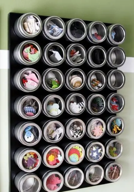 a magnetic board with cans with sheer lids for storing small stuff