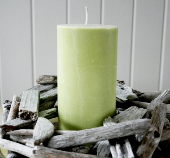 a green candle in a driftwood candle holder is a cool rustic and beachy idea