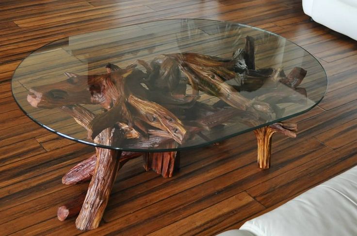 a large coffee table with a driftwood base and a glass tabletop