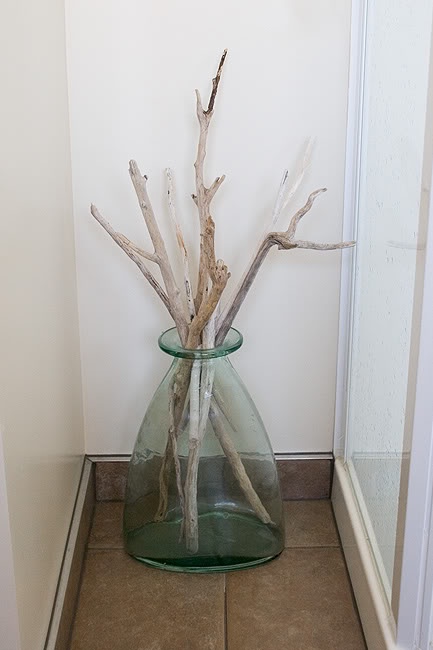 a large glass vase with branches is a cool idea to decorate your home