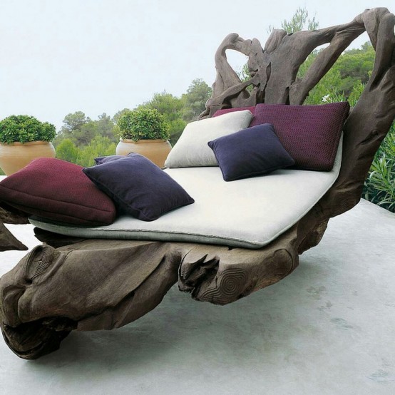 an oversized driftwood furniture piece with cushions and pillows for outdoors