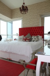 a bright glam bedroom done with bright red touches and a faux stone statement wall – doing that with wallpaper or panels is easy