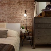 a vintage industrial bedroom is made finished off with an exposed brick wall – it’s a perfect decor feature for such a space