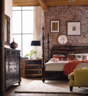 a vintage meets mid-century modern bedroom is made edgy and more harsh with an exposed brick wall