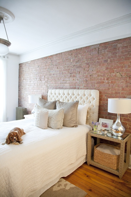 a brick wall, hardwood floors and chic glam furniture make up a gorgeous bedroom combo
