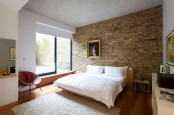 a neutral mid-century modern bedroom would have looked more boring and too polished without a brick wall in sandy tones