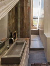 a chalet bathroom with white concrete, with reclaimed wood walls and a rectangular sink of stone is chic and modern