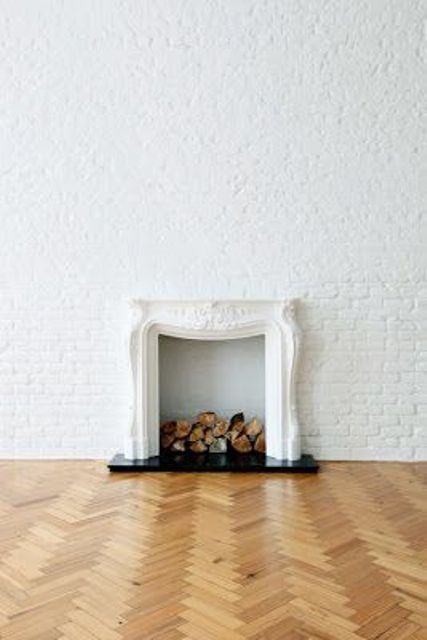 Such a space with whitewashed brick walls and a refined non working fireplace is a chic space with a Parisian feel
