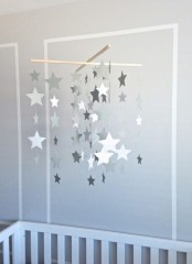a pretty and timeless nursery mobile of grey and white cardboard stars hanging down is a cool idea for a modern neutral or Scandinavian space