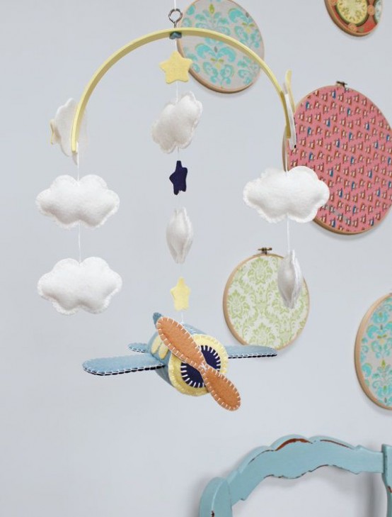 a beautiful mobile with felt clouds and stars plus an airplane is a catchy and bold solution for an airplane-inspired nursery