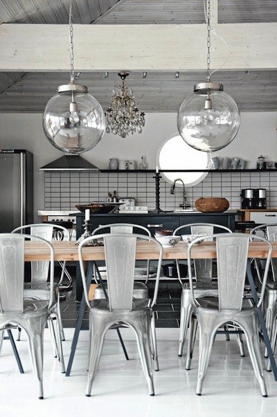 An amazing vintage metal chairs and glass orbs above them are things that make this kitchen special.