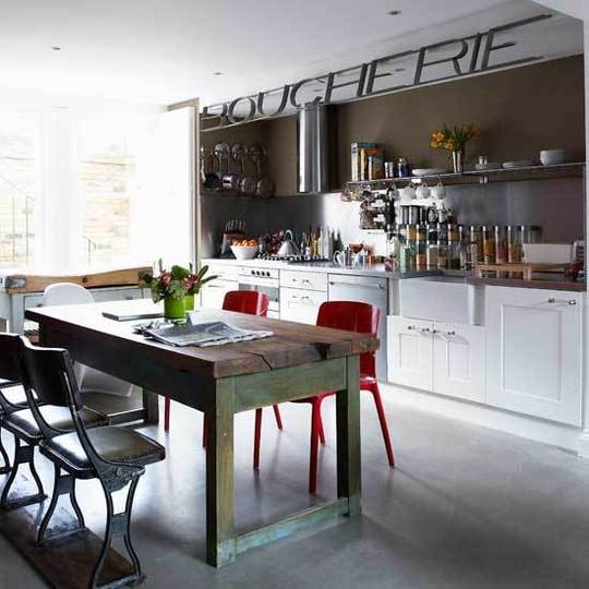 Timeless white kitchen cabinets combined with red chairs and a weathered barn-like dining table make this kitchen look unbelievably good.