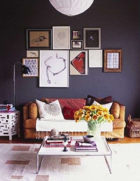 A dark, gloomy wall is not a very popular choice for a living room but it can play out really well. Add some artworks to make it less boring and  slightly soothe the its heaviness.