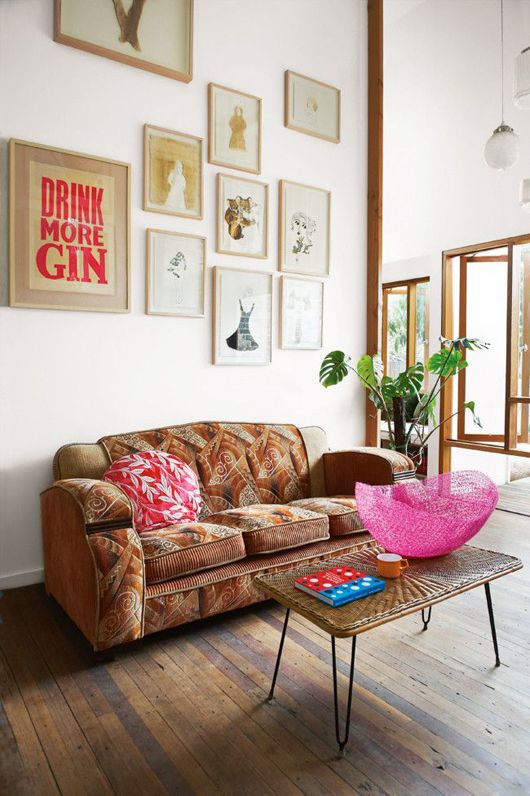 A distinctive gallery wall makes a bold appearance that is so necessary in this clean open-style space. A brown sofa with a cool pattern is also more than welcome addition to the room's decor.