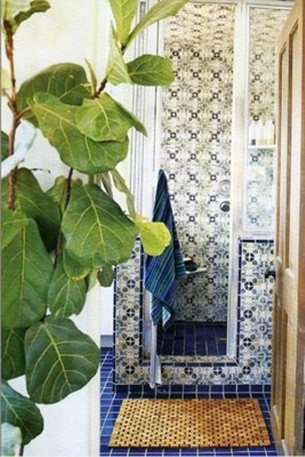 a navy and white Moroccan bathroom with catchy patterned tiles plus potted greenery