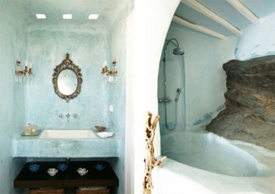 an aqua-colored bathroom done with plaster, with a bathtub of it and an ornated mirror