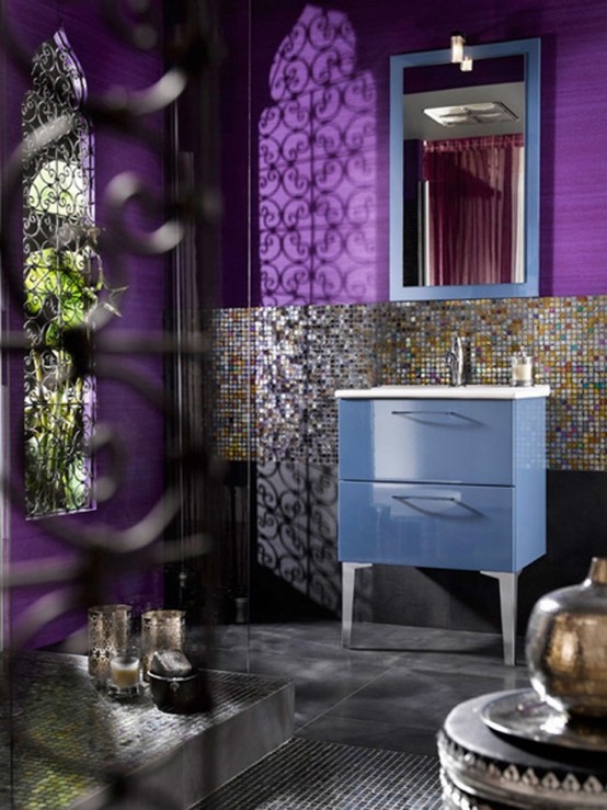 a super colorful Moroccan bathroom with purple walls, catchy tiles, a blue vanity and a blue framed mirror