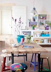 a colorful stool, bright blooms in a blue pots and lots of colorful items and bright shelves make the space springy