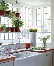 fresh greenery in pots and bright yellow tulips in a bucket will make yoru kitchen more spring-like, bright and fresh