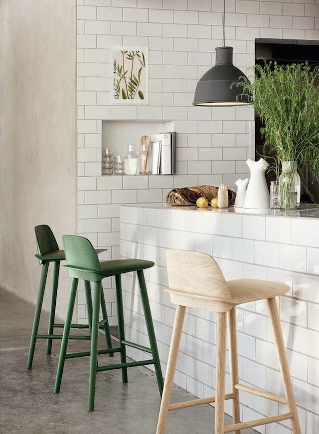 Fresh greenery in a clear jar and green chairs will make the kitchen feel more outdoor like