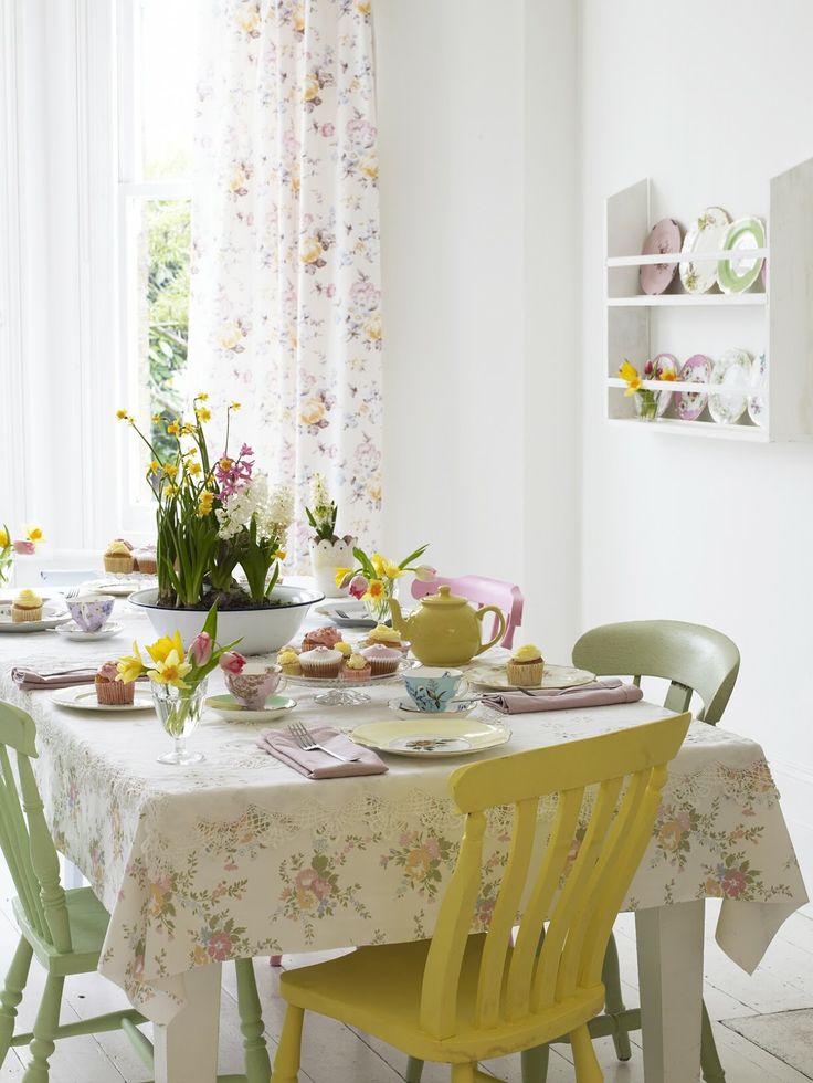 Floral linens, pastel chairs, pastel tableware and plates make the dining space look more spring like