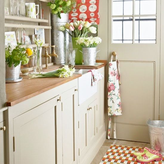 Lots of fresh blooms and greenery in various buckets and floral linens make the kitchen bright, bold and spring infused
