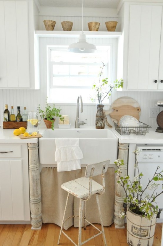 fresh greenery and blooms in vases and pots make the kitchen look more spring-like and blooming itself