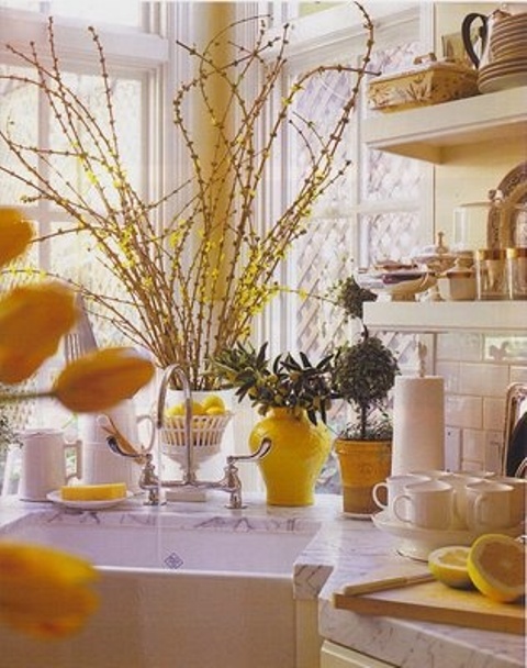 bright yellow blooming branches, bright yellow vases, lemons and pots make the kitchen bright, fun and spring-like