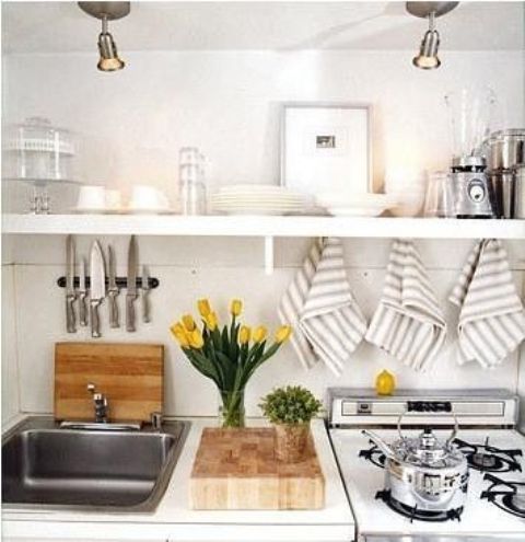 Yellow tulips, fresh greenery in a pot make the kitchen fresher, brighter and more spring like
