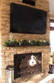 a mantel turned into a planter with greenery and blooms in it and a sign