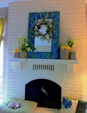 a fresh spring mantel with bright floral spring arrangements and a blooming wreaht over the mantel