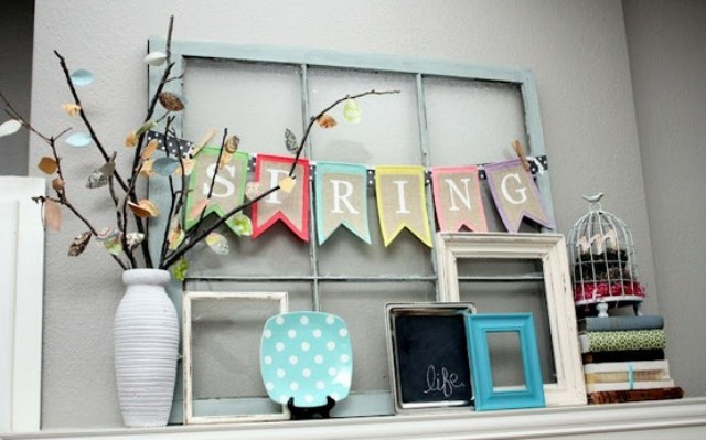 A colorful spring bunting, a decorative plate and a colorful branch arrangement