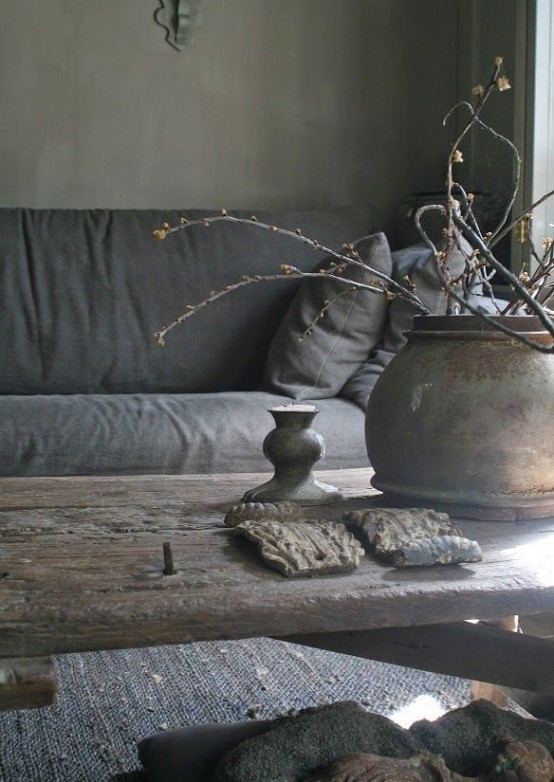 a rough wooden table, a porcelain vase with branches, coarse fabric and some other elements to create a wabi-sabi interior