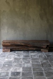 shabby tiles on the floor and a concrete wall plus a rough wooden slab bench for a wabi-sabi entryway