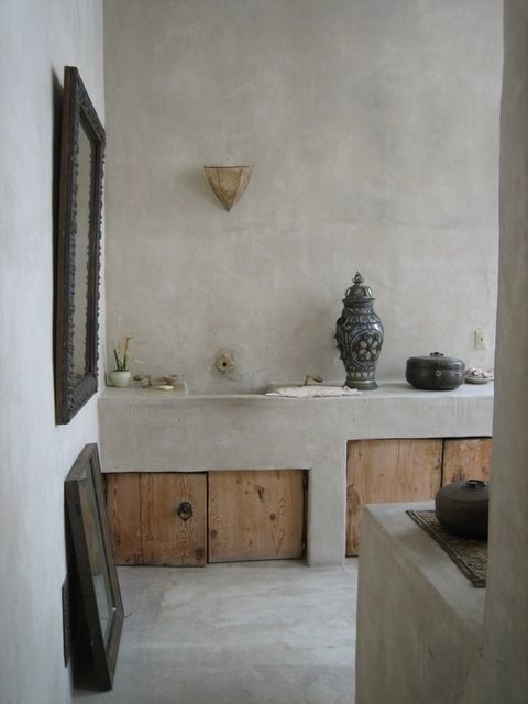 a concrete kitchen with built-in furniture with wooden doors and vintage details and decor
