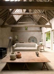 a cozy living room with a wabi-sabi feel – rough concrete walls, a wooden roof and beams