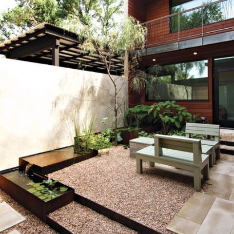 a contemporary backyard with a Japanese feel and a series of ponds with greenery, leaves and a tree next to them