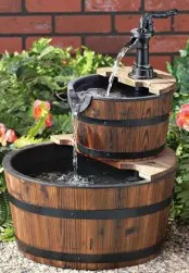 a small tiered rustic fountain composed of wooden buckets and with a black faucet is a creative idea for a rustic space