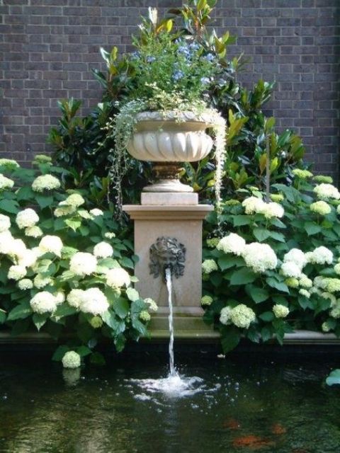 An elegant vintage fountain with a bowl with greenery on top and a large pool or pond for flowing in is a lovely idea for an elegant vintage inspired garden