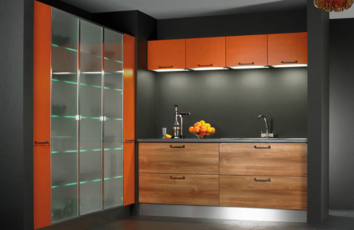 a contemporary kitchen with stained drawers, a grey backsplash and orange uppers, a glass fridge in orange