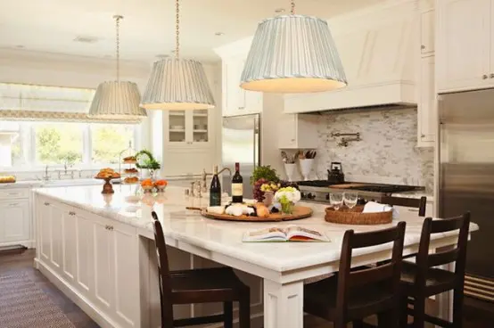 You can separate a long kitchen island into several zones: one for cooking, one for dining and one for storage.