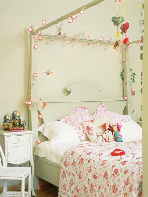 a pastel green girl's bedroom with a canopy bed decorated with blooms, floral bedding, bold hearts, toys and just decor is romantic and pretty